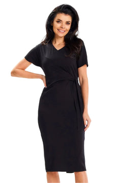 women with hand on hip  smiling in black dress